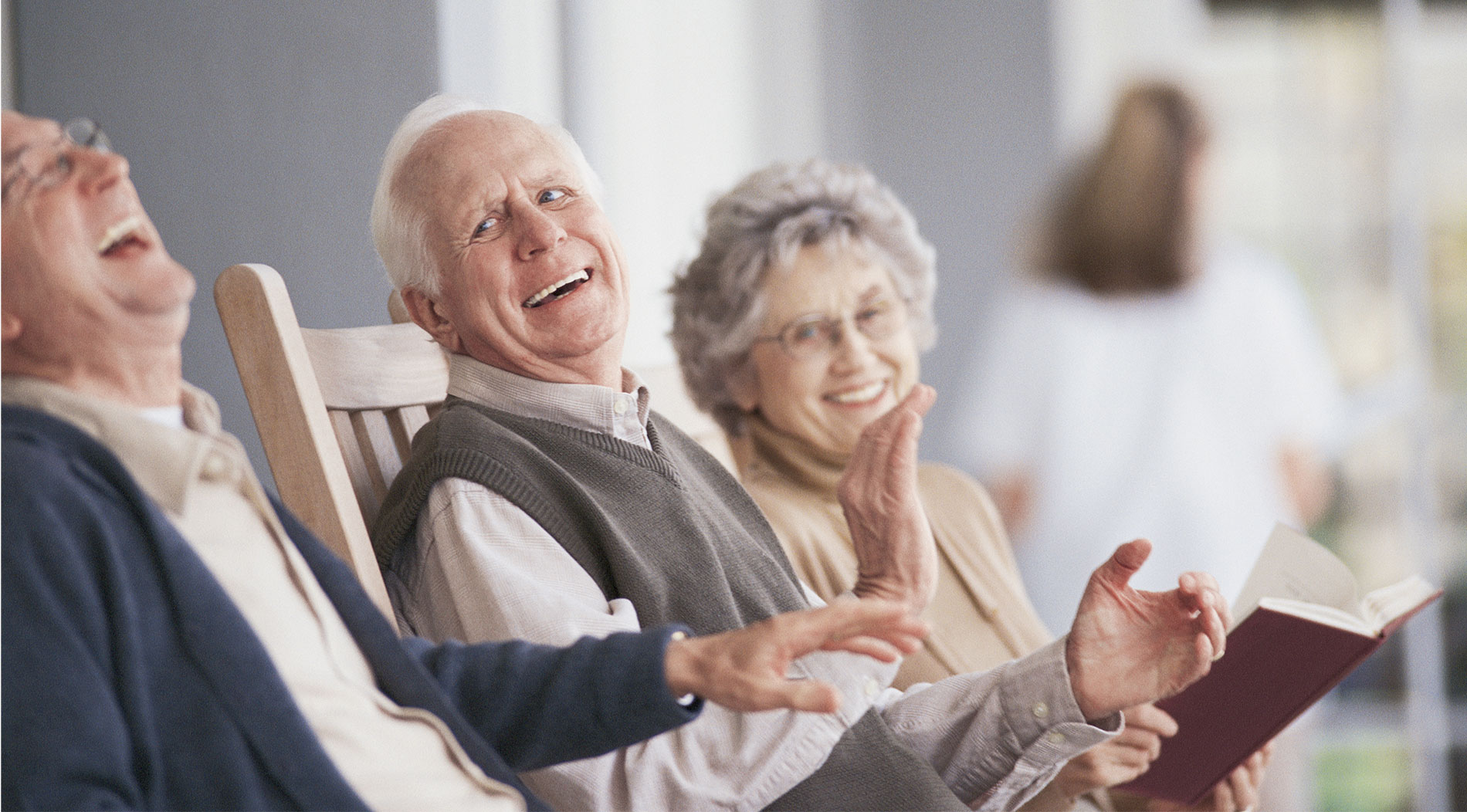 A group of seniors share a laugh on the porch of their senior living community in Marana.