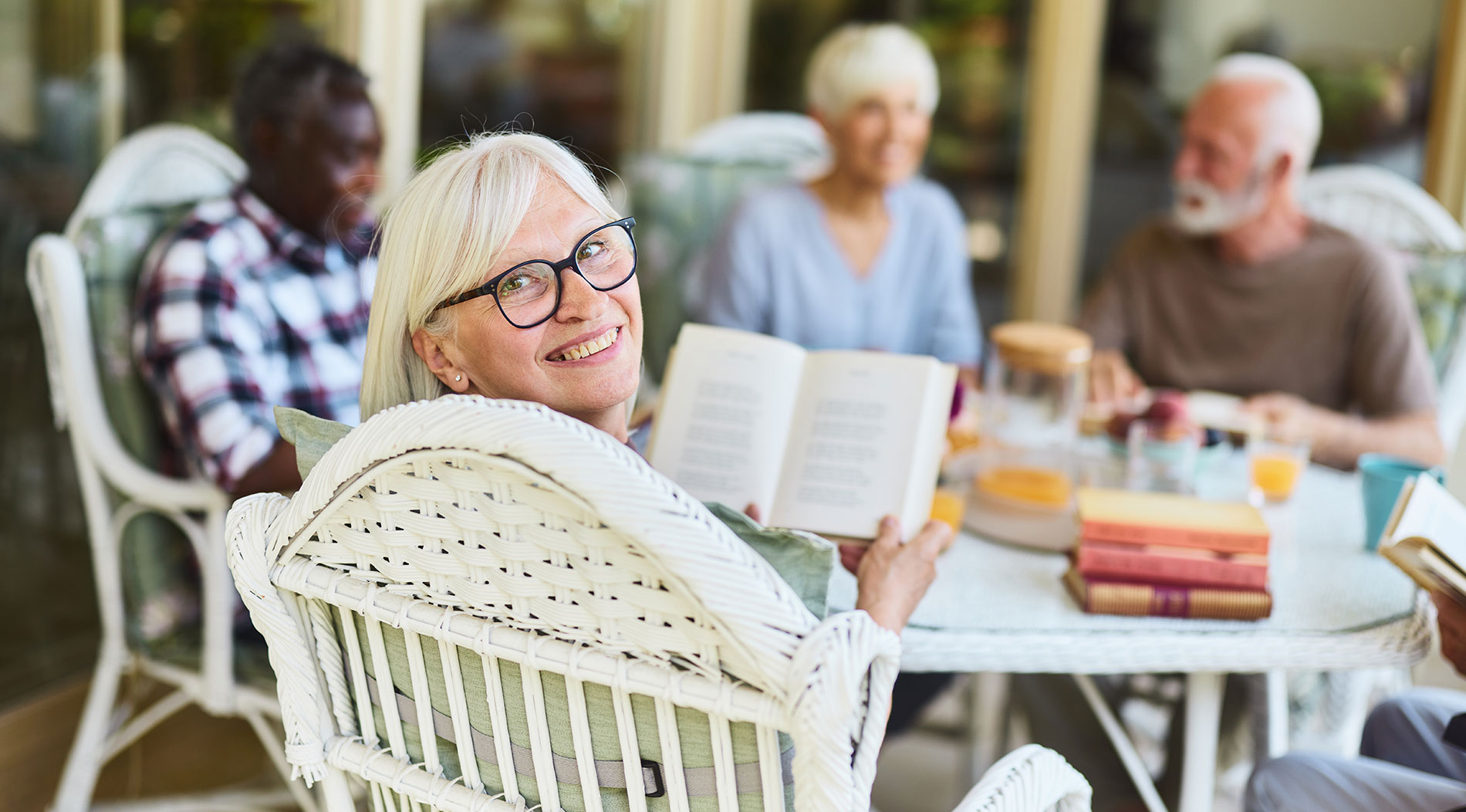 A group of seniors share a laugh on the porch of their senior living community in Marana.
