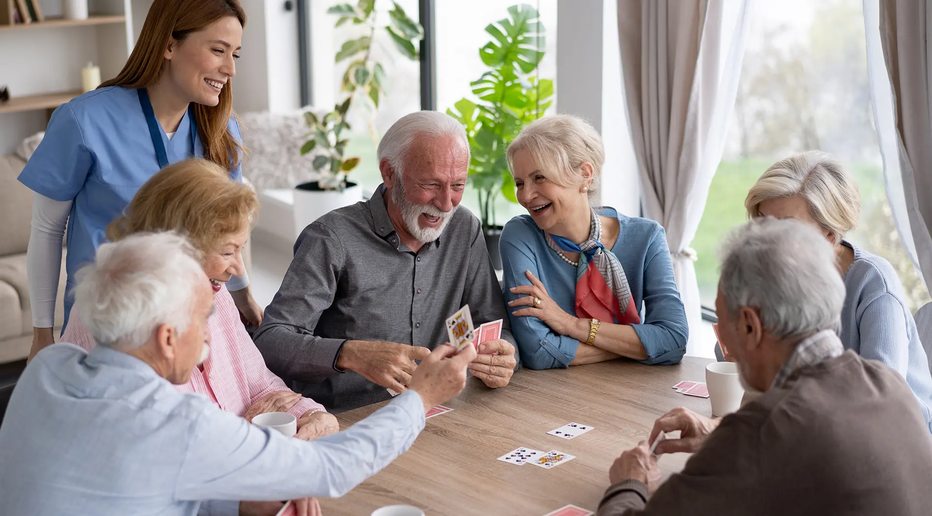 assisted-living-placement_1900x1052 A group of older adults who utilized senior placement services in Pima County laugh together as they enjoy cake and coffee.